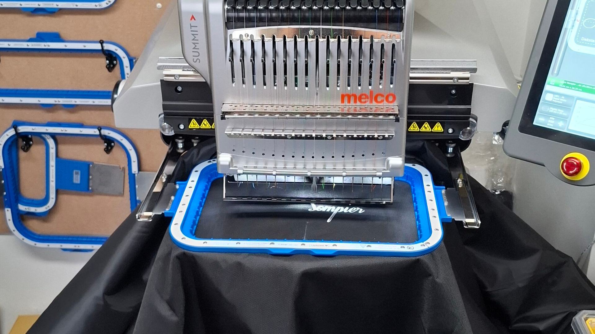 Borduurmachine met meerdere kleuren garen bezig met logo borduren op kleding bij BORDRUKT